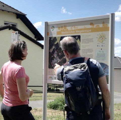 Wanderer informieren sich an der Wandertafel, © Tourist-Information Bitburger Land