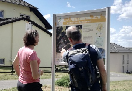 Wanderer informieren sich an der Wandertafel, © Tourist-Information Bitburger Land