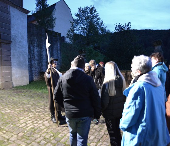 Der Nachtwächter begrüßt die Gruppe am Tor, © TI Bitburger Land